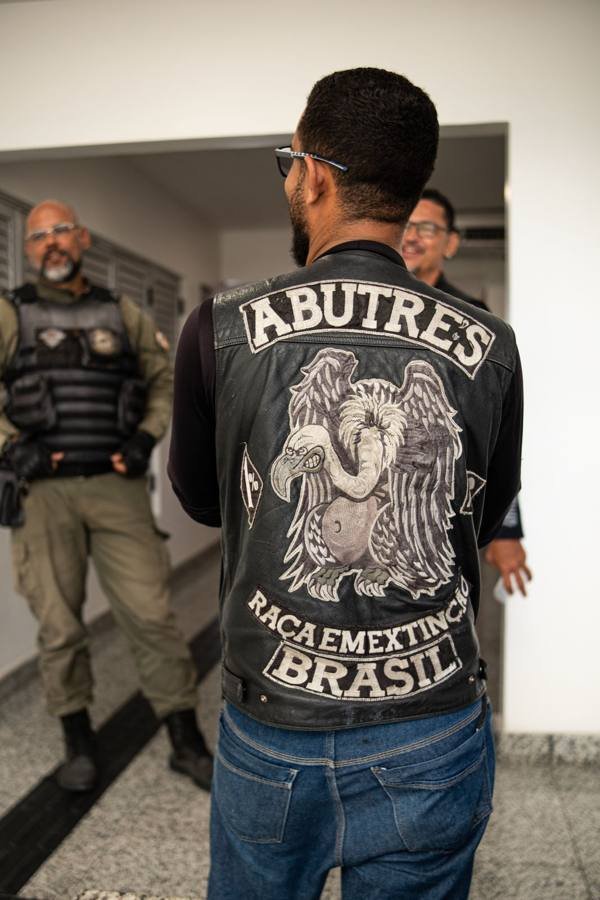 Motociclista de costas, com colete de couro, dentro do hemocentro